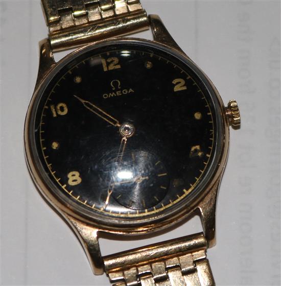 A gentlemans 1940s 9ct gold Omega wrist manual wind watch, with black Arabic dial on rolled gold bracelet.